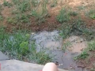 A little 18 years old lady plays with a hose outdoors in jemagat öňünde